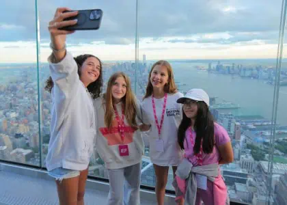 A group of young girls take a selfie at The Edge overlooking New York City