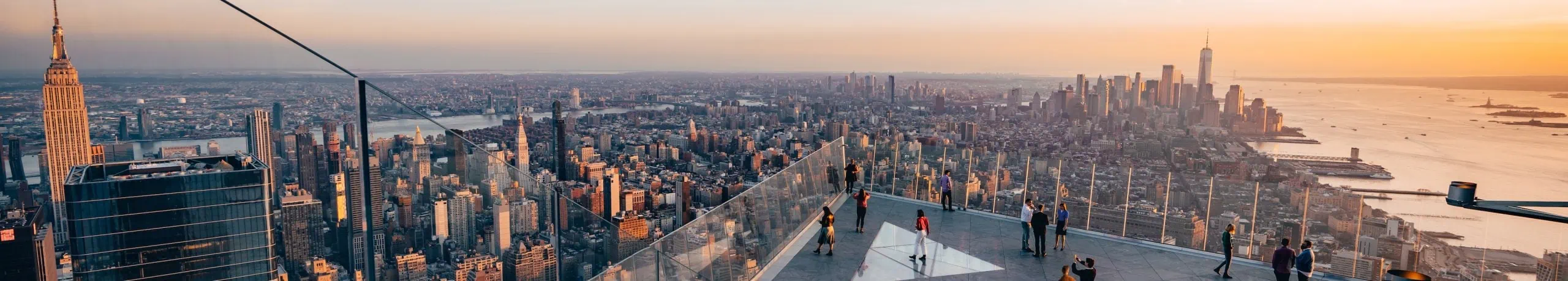 Guests enjoying outdoor sky deck at Edge NYC overlooking the Manhattan skyline.