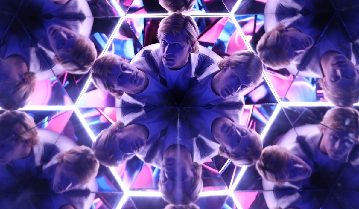 Person surrounded by colorful neon lights and mirrors in the Kaleidoscope room, an immersive installations at Edge NYC, 30 Hudson Yards