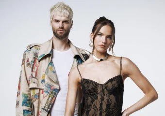 Two artists posing against a plain background, one male and one female.