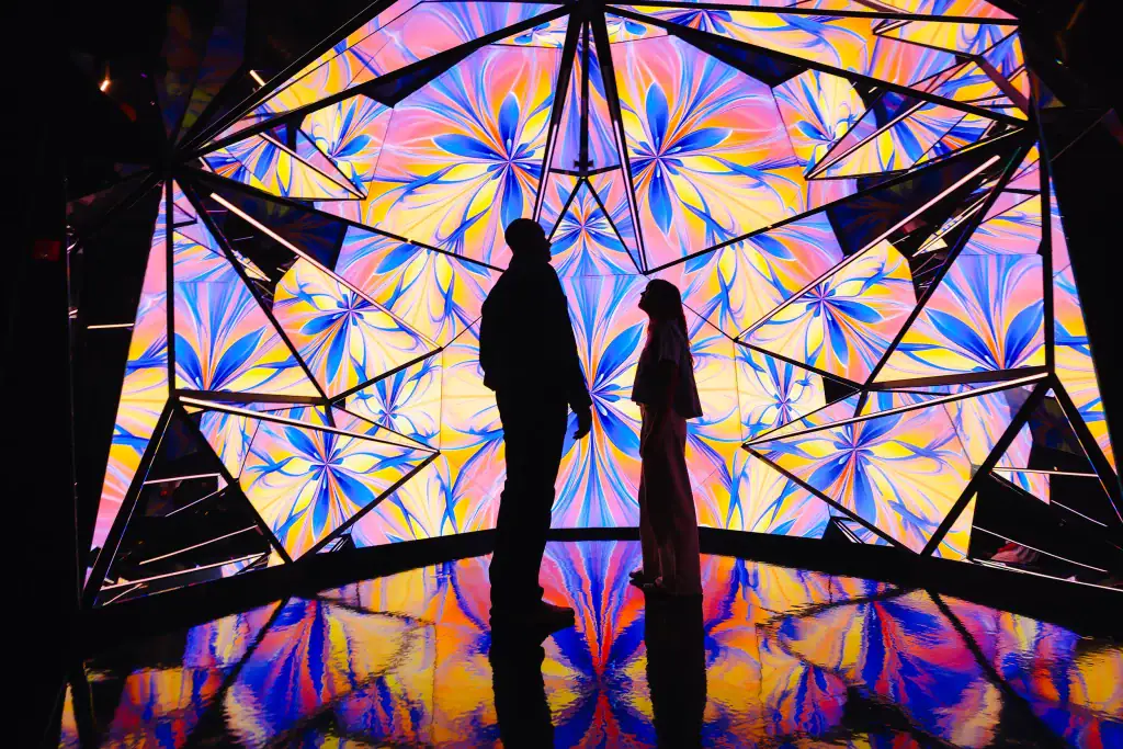 two-people-looking-at-kaleidoscope-immersive-experience-at-edge - Edge NYC - Edge NYC Two people stand inside the kaleidoscopic room at Edge NYC.