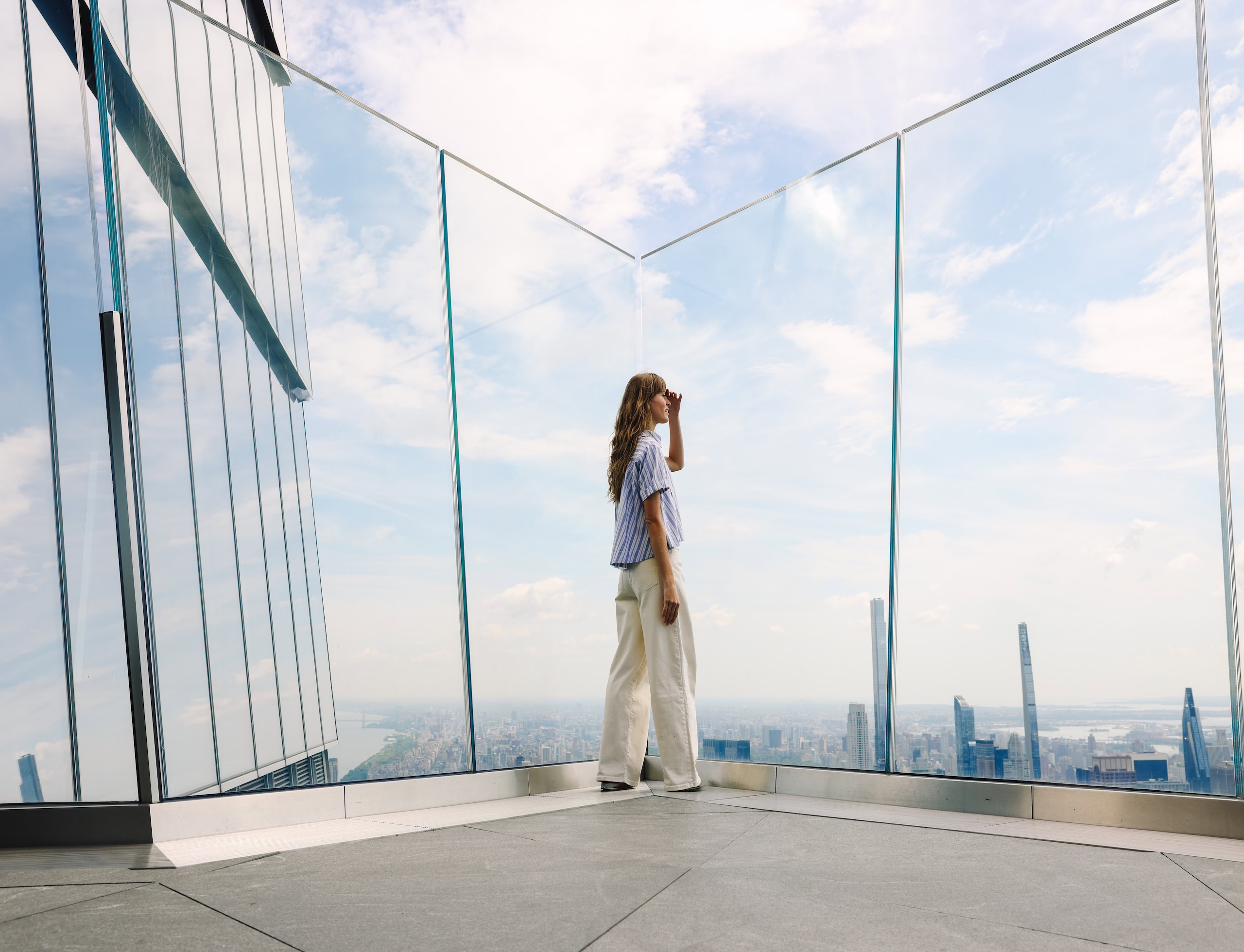 Woman enjoying panoramic skyline view from Edge NYC sky deck.