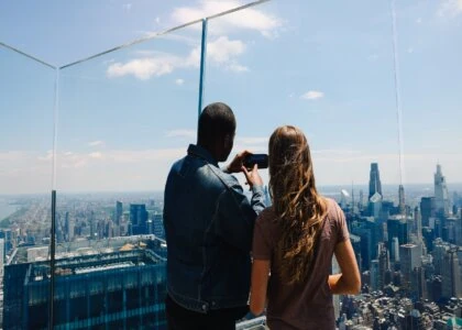 Two visitors enjoy panoramic NYC skyline from Edge NYC sky deck.