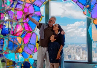 Family enjoying panoramic NYC skyline from Edge NYC sky deck with colorful art installation.