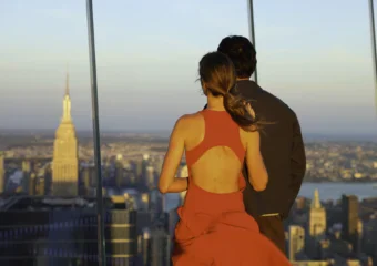 Couple enjoying panoramic skyline view from Edge NYC sky deck at sunset.