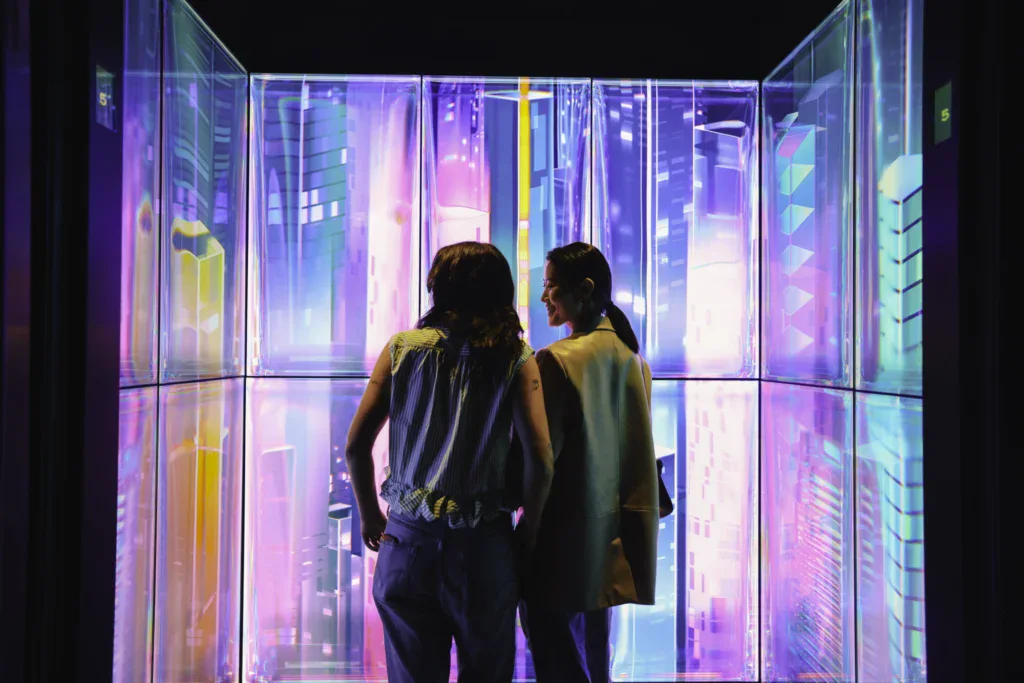 Edge NYC Immersive Art Installation - Edge NYC - Edge NYC Two visitors viewing colorful digital art display at Edge NYC sky deck.